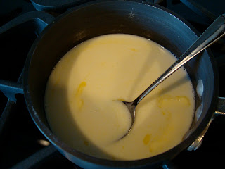Coconut milk in sauce pan with spoon