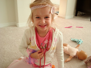 Dressed up young girl with toys sitting and smiling