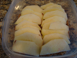 Peeled and sliced apples over blended crust mixture in clear container
