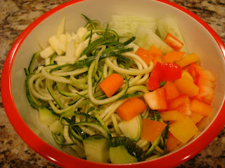 Spiralized zucchini with bell peppers and cucumber in bowl