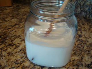 Spoon stirring kefir in glass jar