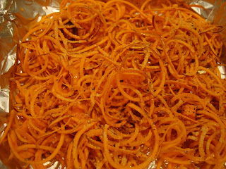 Spiralized sweet potato with ginger, olive oil, salt and pepper on foil lined pan