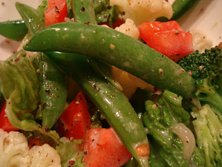 Closeup of some snap peas in salad showing dressing