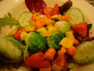 Mixed greens and vegetables with salad dressing in white shallow dish