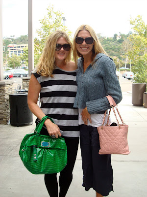 Two women holding purses smiling
