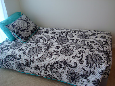 Side view of bed spread on bed next to wall