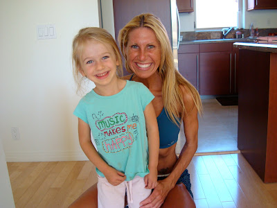Woman in workout clothes with young girl smiling