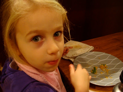 Young girl sitting at table eating