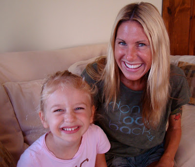 Young girl and woman sitting on couch smiling