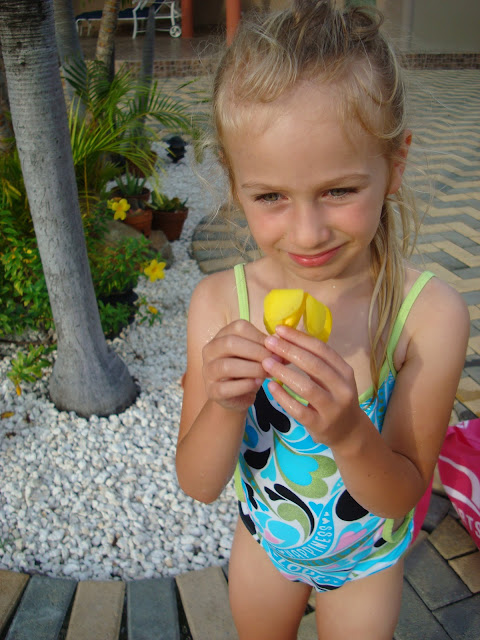 Young girl in swimsuit holding flower
