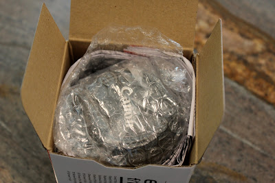 Open box with lens wrapped in plastic