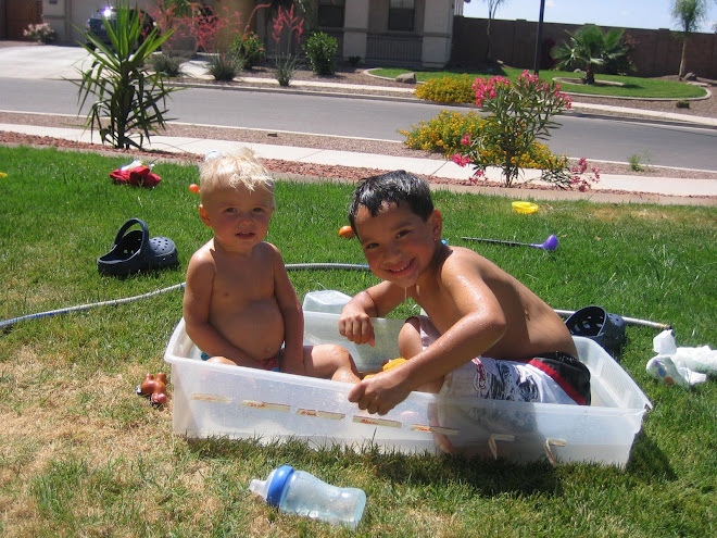 Kolton and Ekika play in water in the front yard
