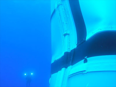 Bajo el agua, el SRB del Ares I-X con un buceador de fondo