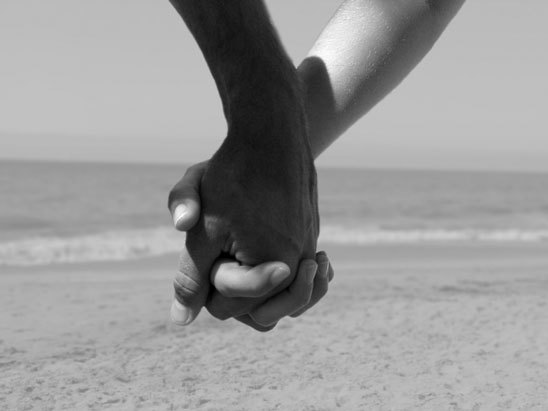 Stock photo : Four Young People, Two Couples, Holding Hands On A Beach