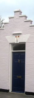 Front door with cricket bat and ball motif above