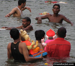 people carrying the clay idols into the Pench river for visarjan