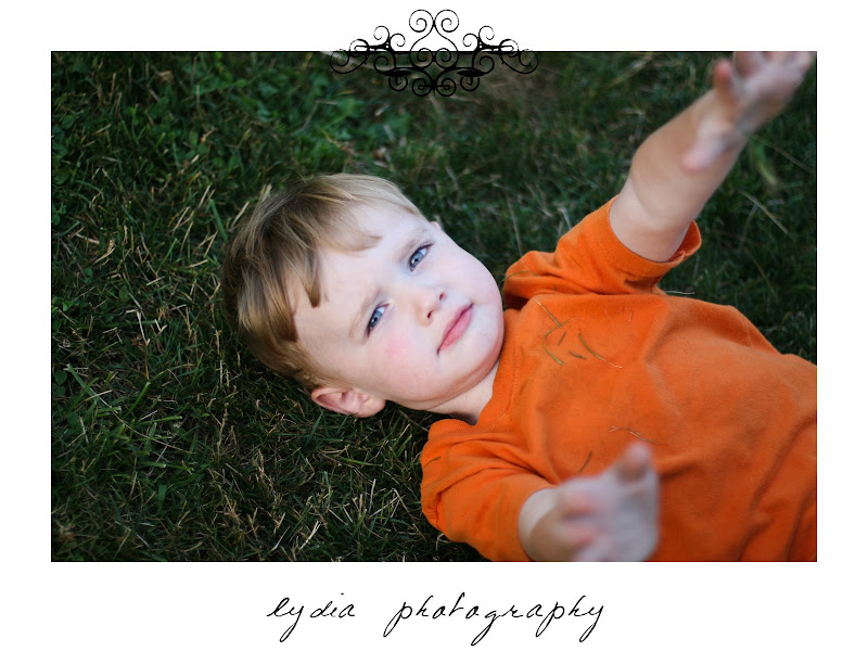 Little boy laying on the grass at lifestyle kids portraits on a farm in Indiana, Pennsylvania
