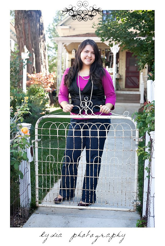 Senior girl standing behind a gate at American Christian Academy senior lifestyle portraits in Grass Valley, California