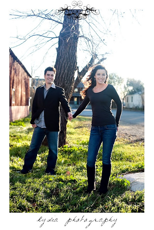 Bride and groom pose in front of an old oak tree at lifestyle old town engagement portraits in Cottonwood, California