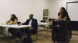 Panelists and moderator listening intently to a participant
