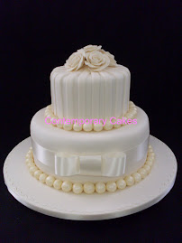 2 tier round atacked with stripes and sugar roses and sugar pearls.
