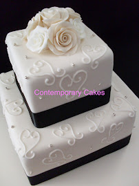 2 tier square cake with piped heartswirls and sugar roses