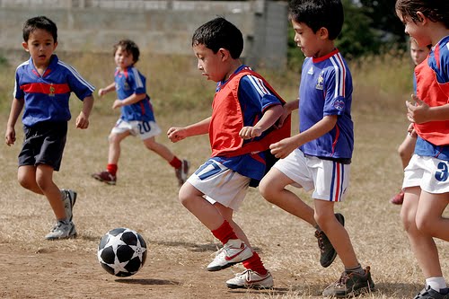 Niños Niños Niños jugando fútbol juego. Ejecutando en jugadores de