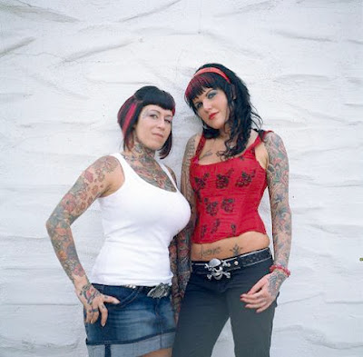 Two women with their sleeves full of flower tattoos, star tattoo, etc.
