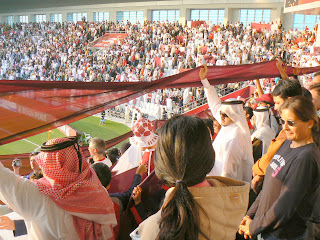 Qataris wave a banner in support of their team