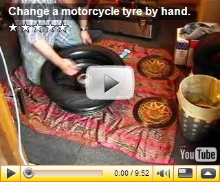 Change a motorcycle tyre by hand.