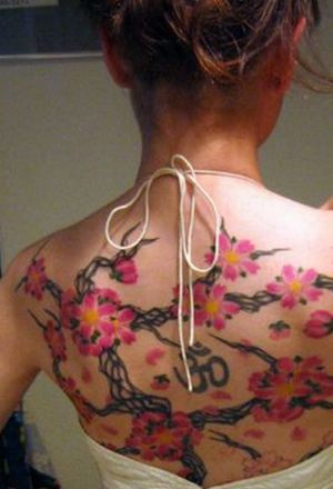 What really sets this cherry blossom tattoo apart is the Hindu “Om” symbol 