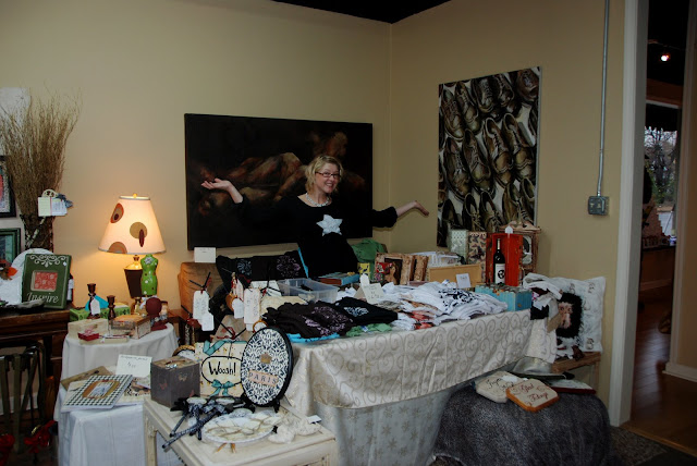 Jennifer Rizzo at an artist market with her goods at a table