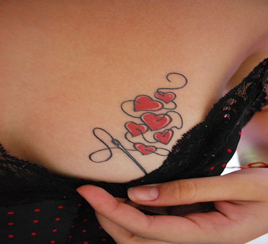 Little needled hearts tattoo on the breast looks simply awesome 