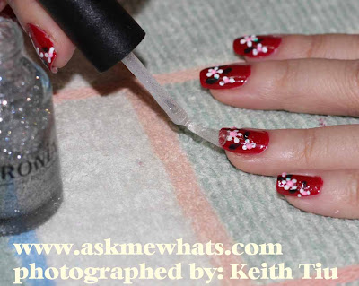 Thinly apply any glittery polish on top of the nail art