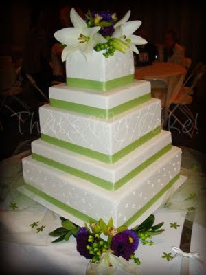 Elegant square white wedding cake with green ribbon trimming and green 