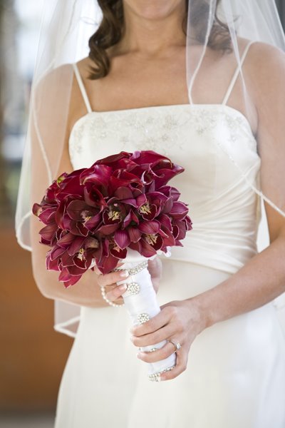 Burgundy calla lilies surrounded by red orchids