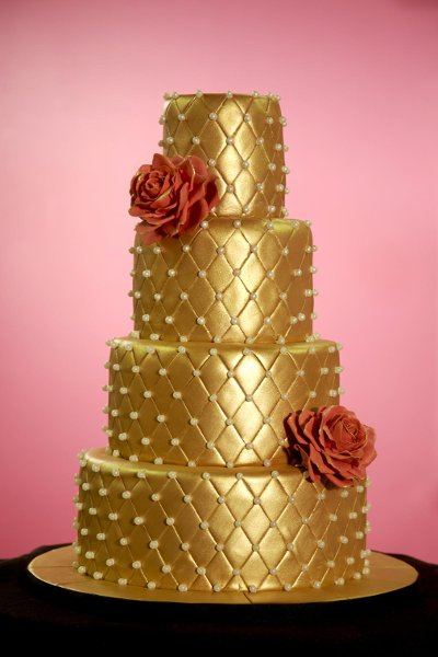 Four tier quilted gold wedding cake with two red roses