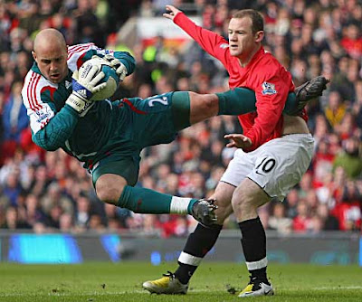 Wayne Rooney of Manchester United tangles with Liverpool goalkeeper Jose Reina during their Premier League match at Old Trafford on March 23, 2008 in Manchester, England.