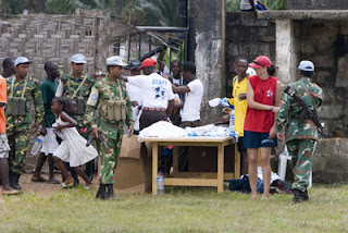 UN Soldiers supervise the distribution of football shirts