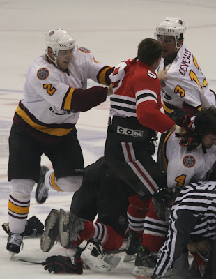 Credit: Jane Rickard, Wolf Brian Fahey pulls Hog Captian Jim Fahey off of his line partner, Boris Valabik during a first period line brawl.