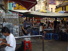Local street musician playing "Bob Dylan Songs" for cafe tourists at "China Town in Petaling.