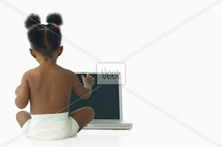 baby sitting in front of a laptop