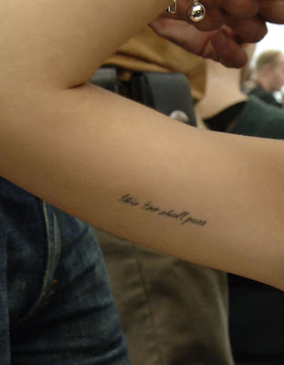 "This Too Shall Pass" on the inside of her upper right arm