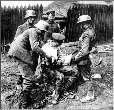 A German soldiers dresses a wounded British soldier