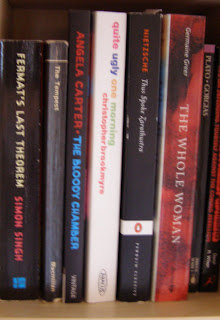 Some red and black books with a colourful one in the middle