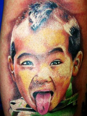 Kid sticking out tounge tattoo.