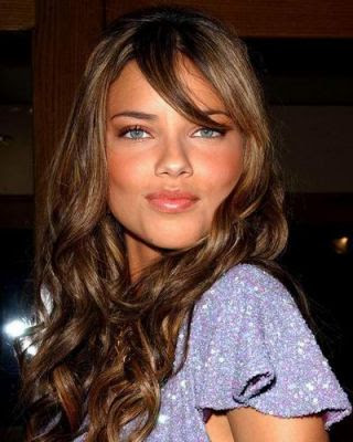 Adriana Lima long wavy hairstyle with partial bangs.