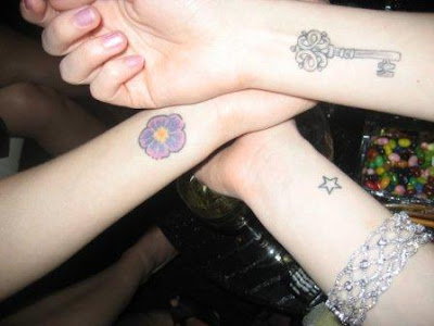 Flower, key and star wrist tattoos.