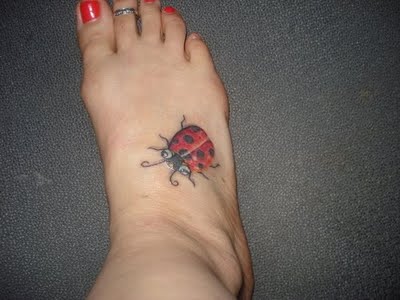 Big ladybug tattoo on foot.