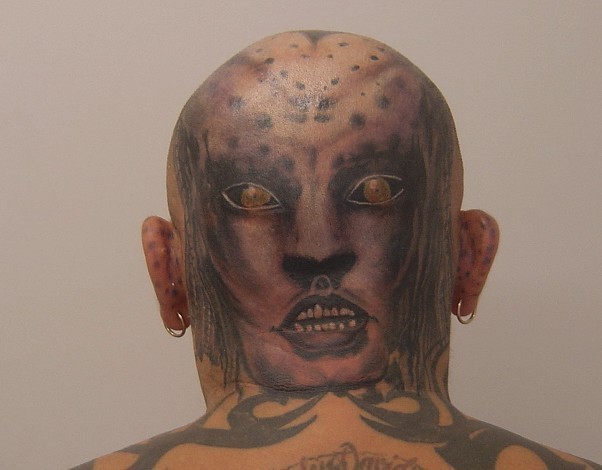 Scary cat man face tattoo with tribal elements
